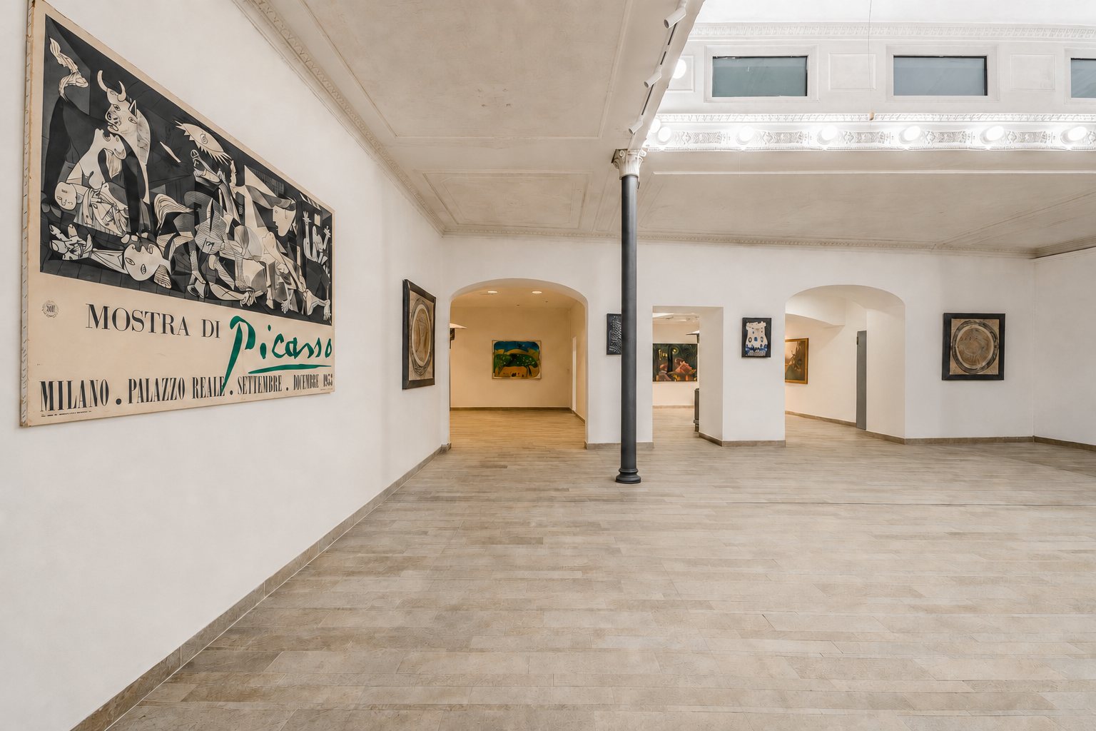 Studio Liberty — la sala libera con i passaggi ad arco e il manifesto della mostra di Picasso